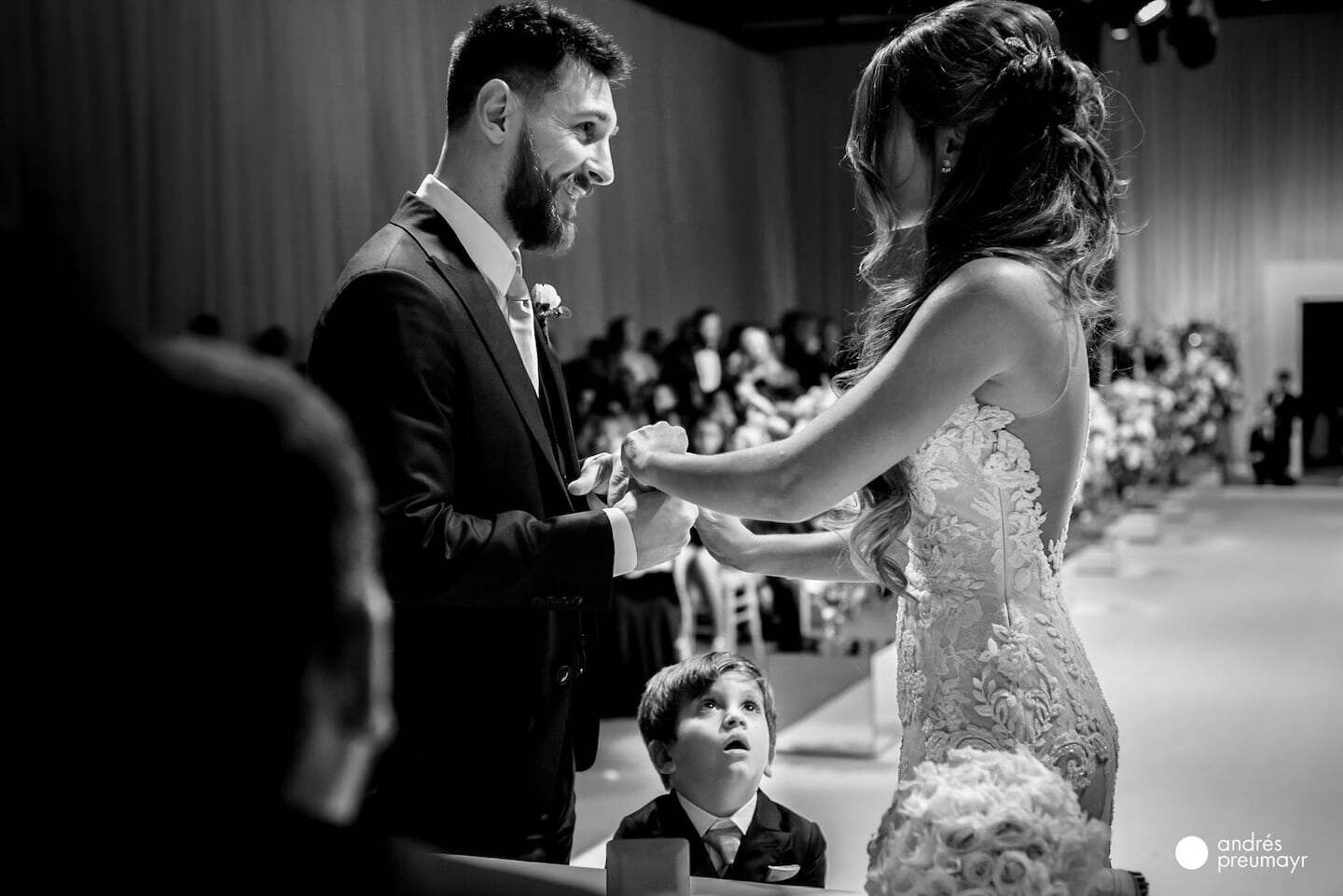 Lionel Messi y Antonela Roccuzzo durante su boda, con un niño observando atentamente