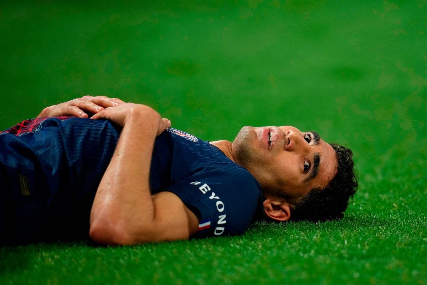 Achraf Hakimi tumbado en el campo durante un partido de fútbol
