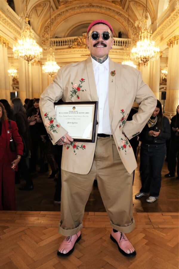 Adrián Appiolaza posando con un certificado en un evento de despedida en Moschino