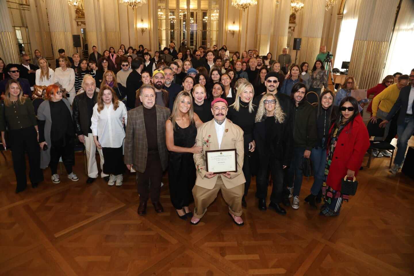 Adrián Appiolaza rodeado de un grupo de personas en un evento de despedida en Moschino