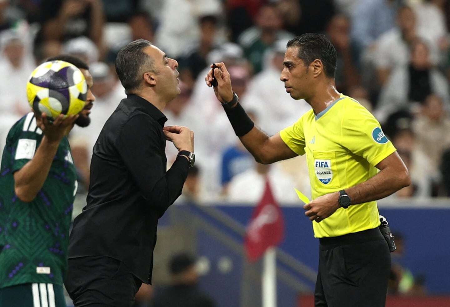 Árbitro Amin Mohamed Omar mostrando una tarjeta amarilla durante un partido de fútbol
