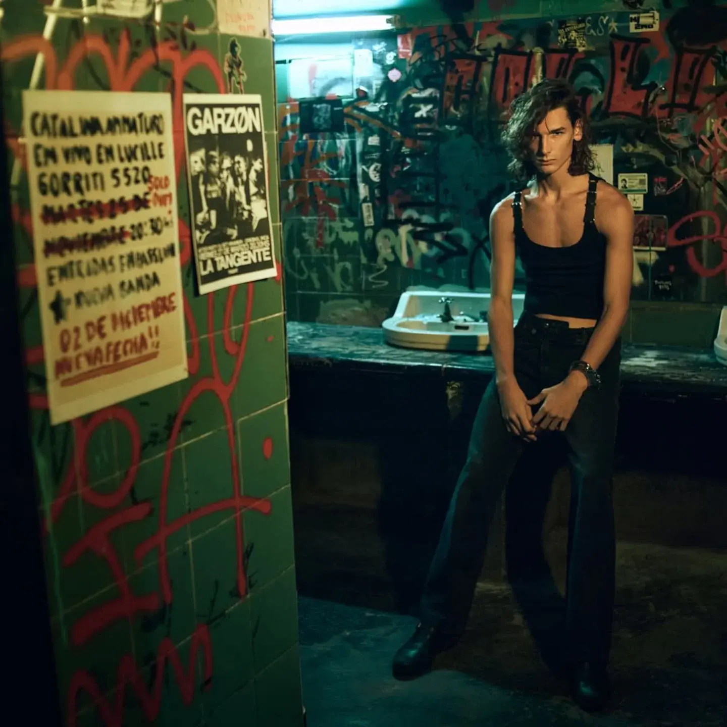 Ángelo Mutti Spinetta posando en un baño con graffiti, luciendo un estilo genderless