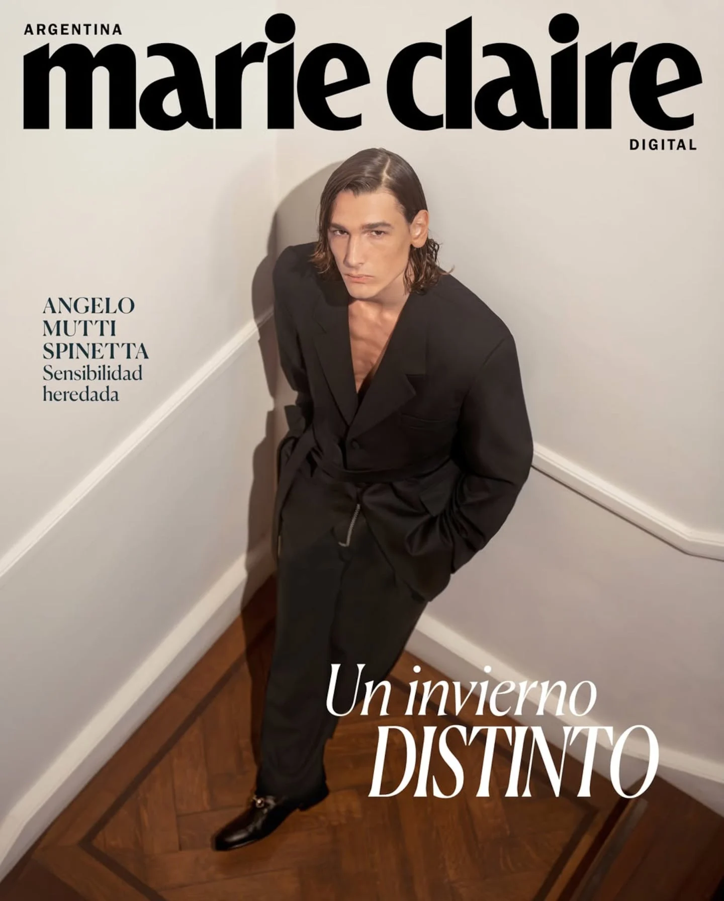 Ángelo Mutti Spinetta posando en una escalera con un traje negro elegante