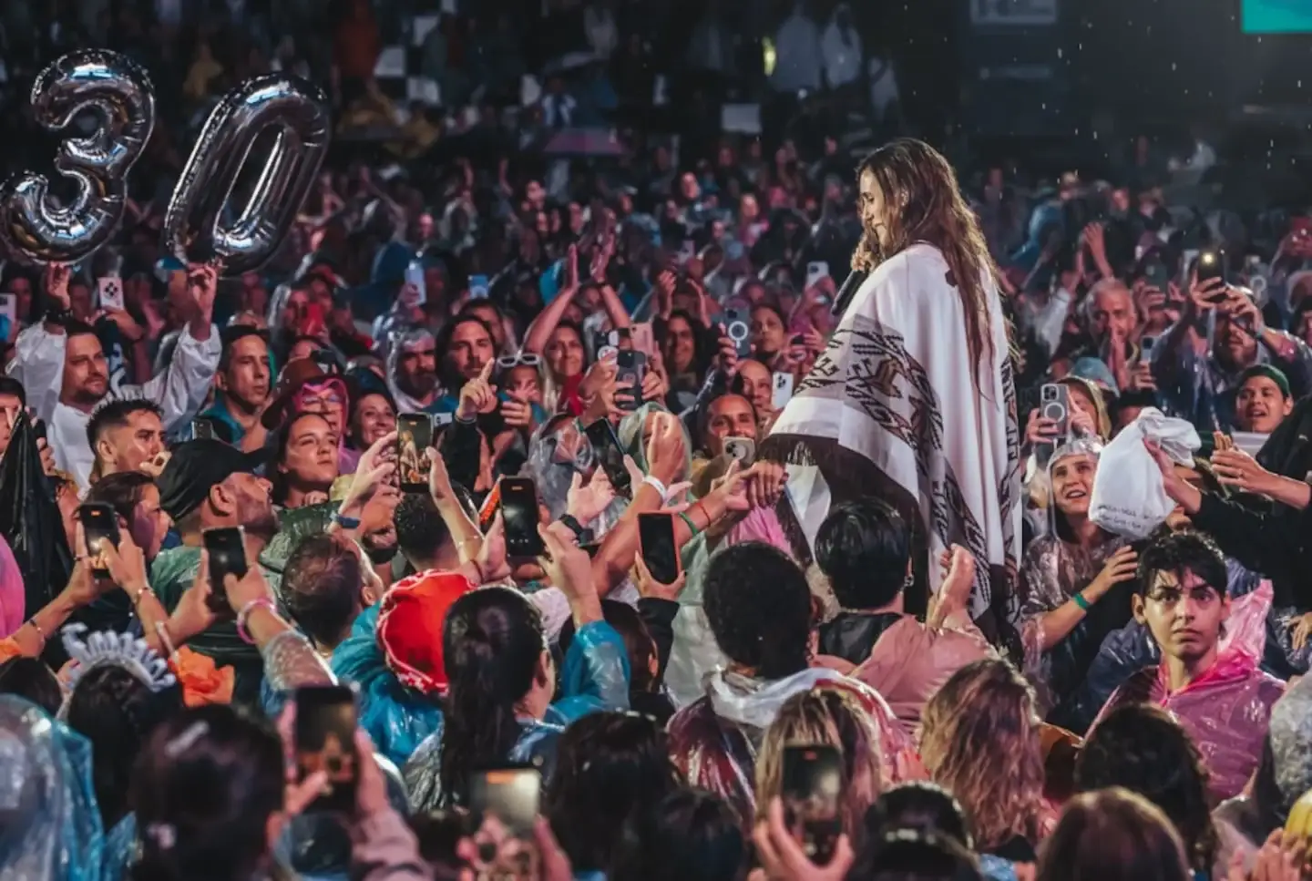 Artista en el escenario interactuando con el público durante un festival de música