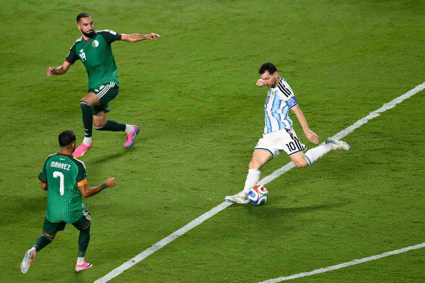 Lionel Messi ejecutando un tiro mientras es marcado por jugadores argelinos en el Mundial 2026