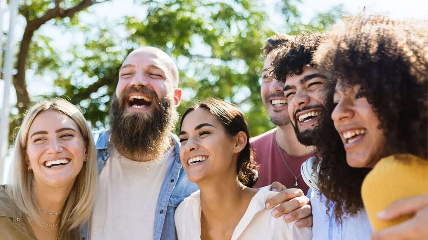 Grupo de amigos riendo y disfrutando juntos al aire libre
