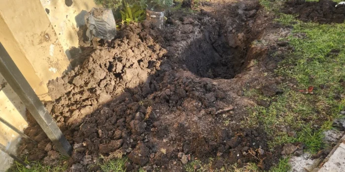 Excavación en el suelo junto a una pared, posiblemente relacionada con un crimen