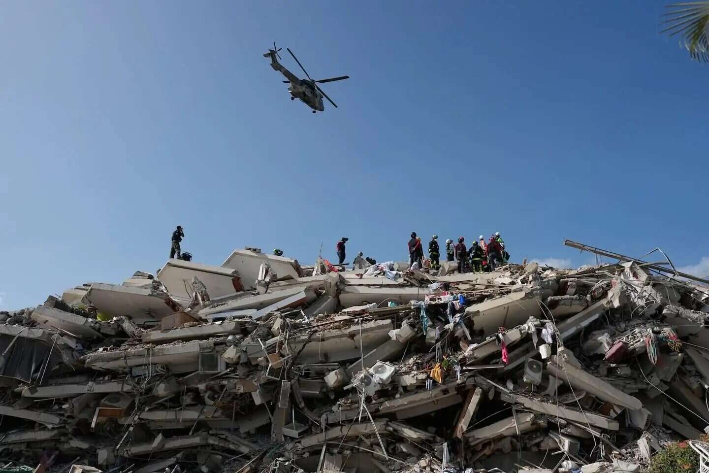 Rescatistas trabajan entre escombros tras un terremoto en Venezuela, con un helicóptero sobrevolando la zona
