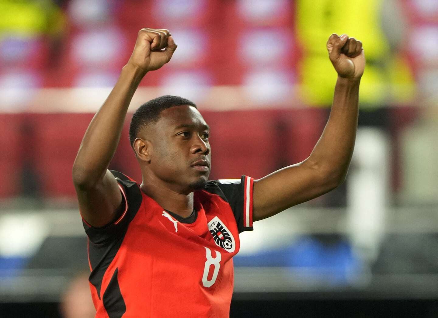 Jugador de fútbol austriaco celebrando con los brazos en alto