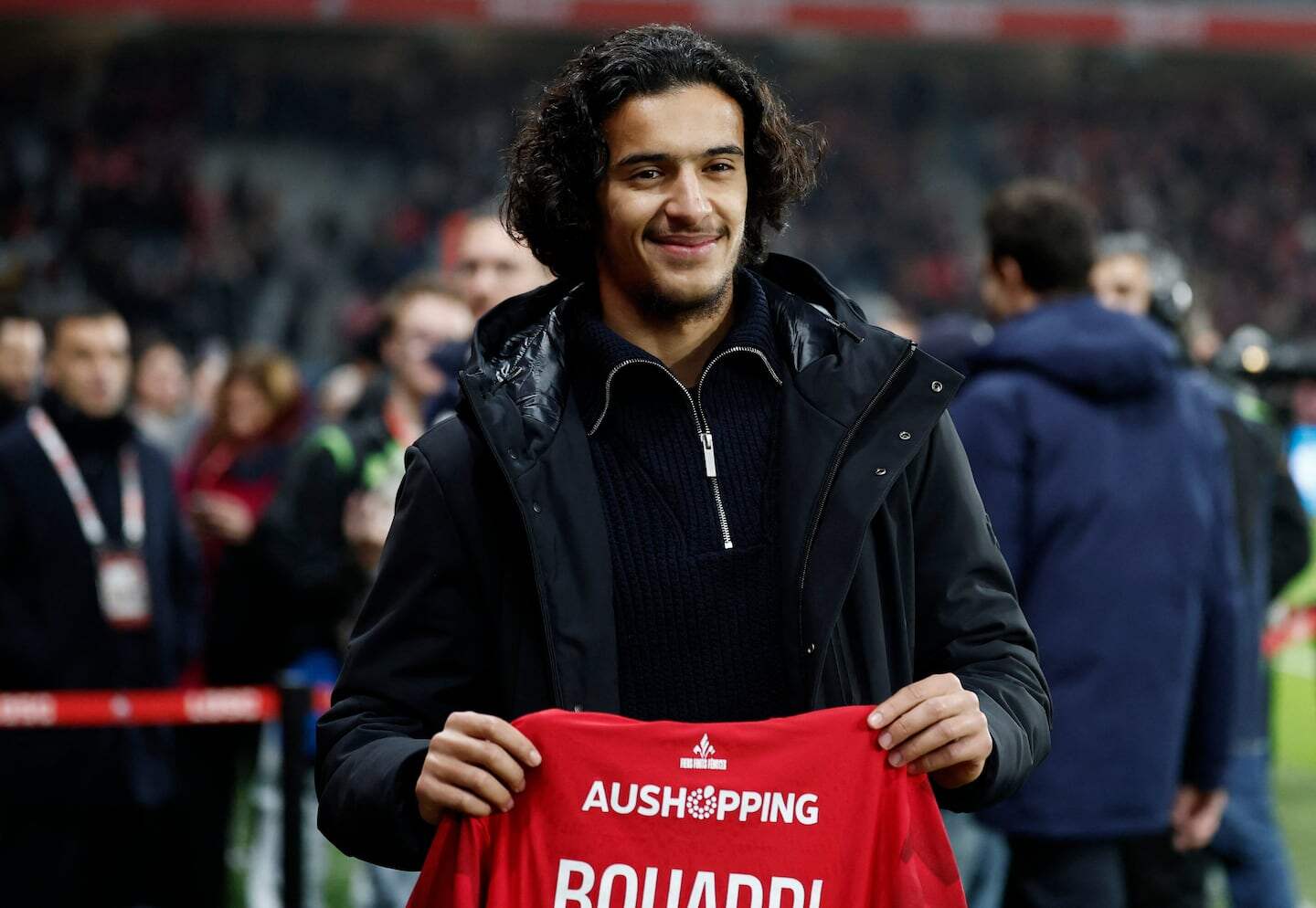 Ayyoub Bouaddi sosteniendo una camiseta con su nombre en un evento deportivo