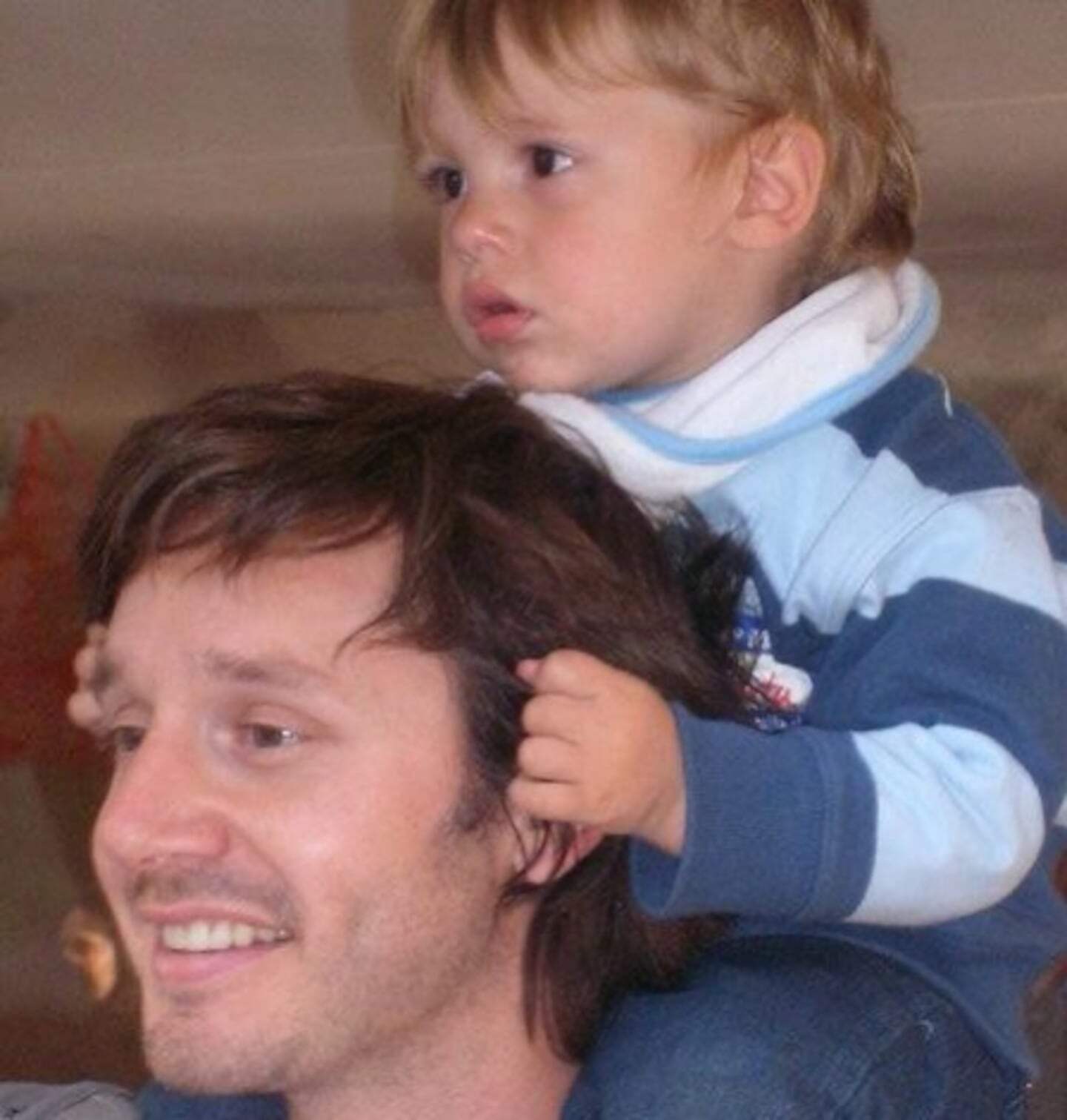 Benjamín Vicuña sonríe mientras su hijo pequeño se sienta sobre sus hombros