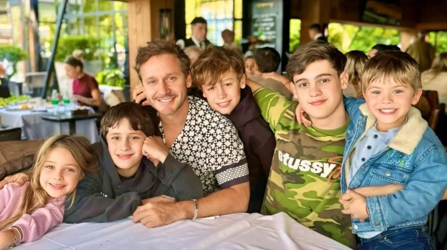 Benjamín Vicuña posando con sus hijos en un restaurante