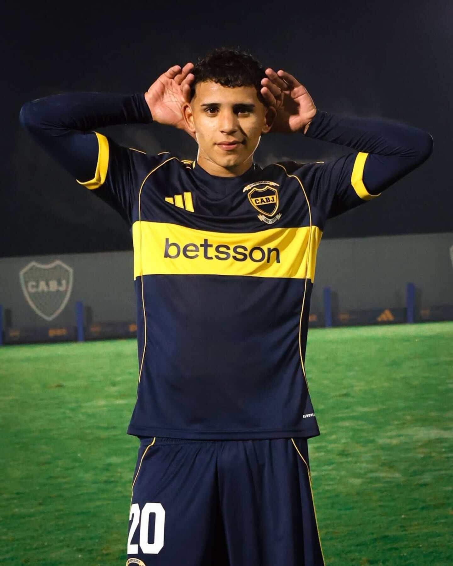 Jugador de Boca Juniors con camiseta amarilla y azul en el campo de entrenamiento