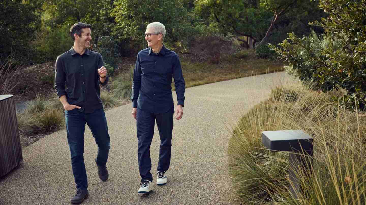John Ternus y Tim Cook caminando por un sendero en un entorno natural