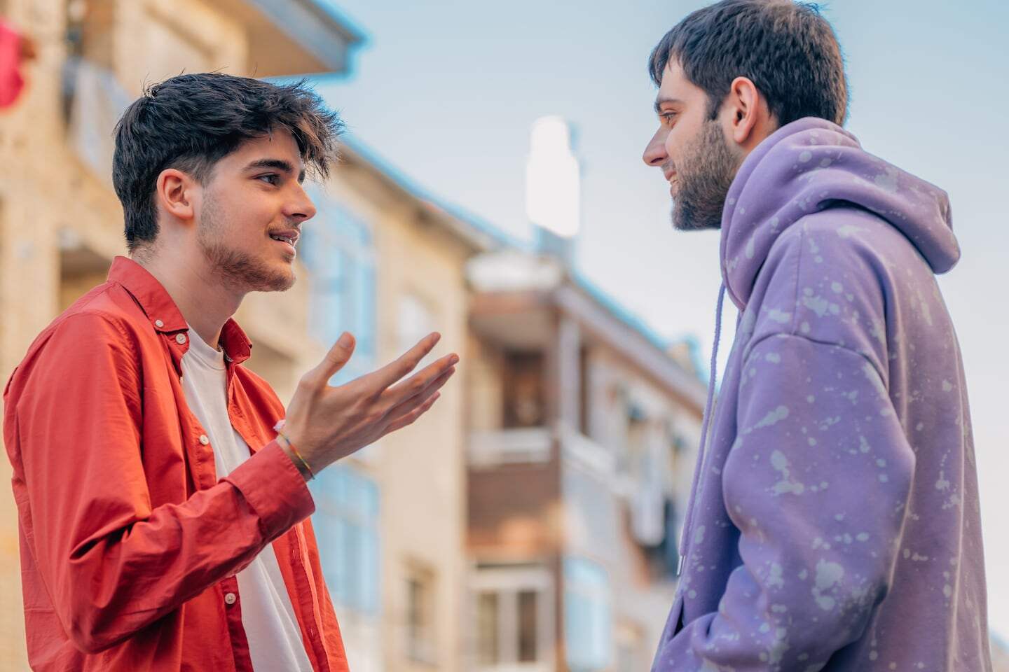 Dos jóvenes conversando en la calle, reflejando un diálogo sobre temas contemporáneos