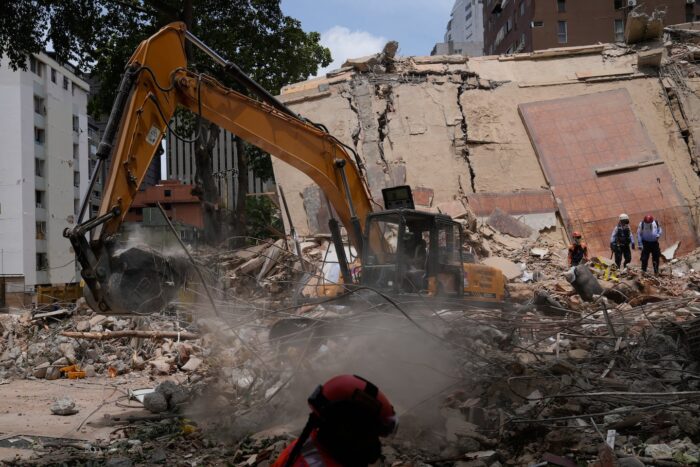 Maquinaria pesada trabajando en los escombros de un edificio colapsado tras un terremoto en Venezuela