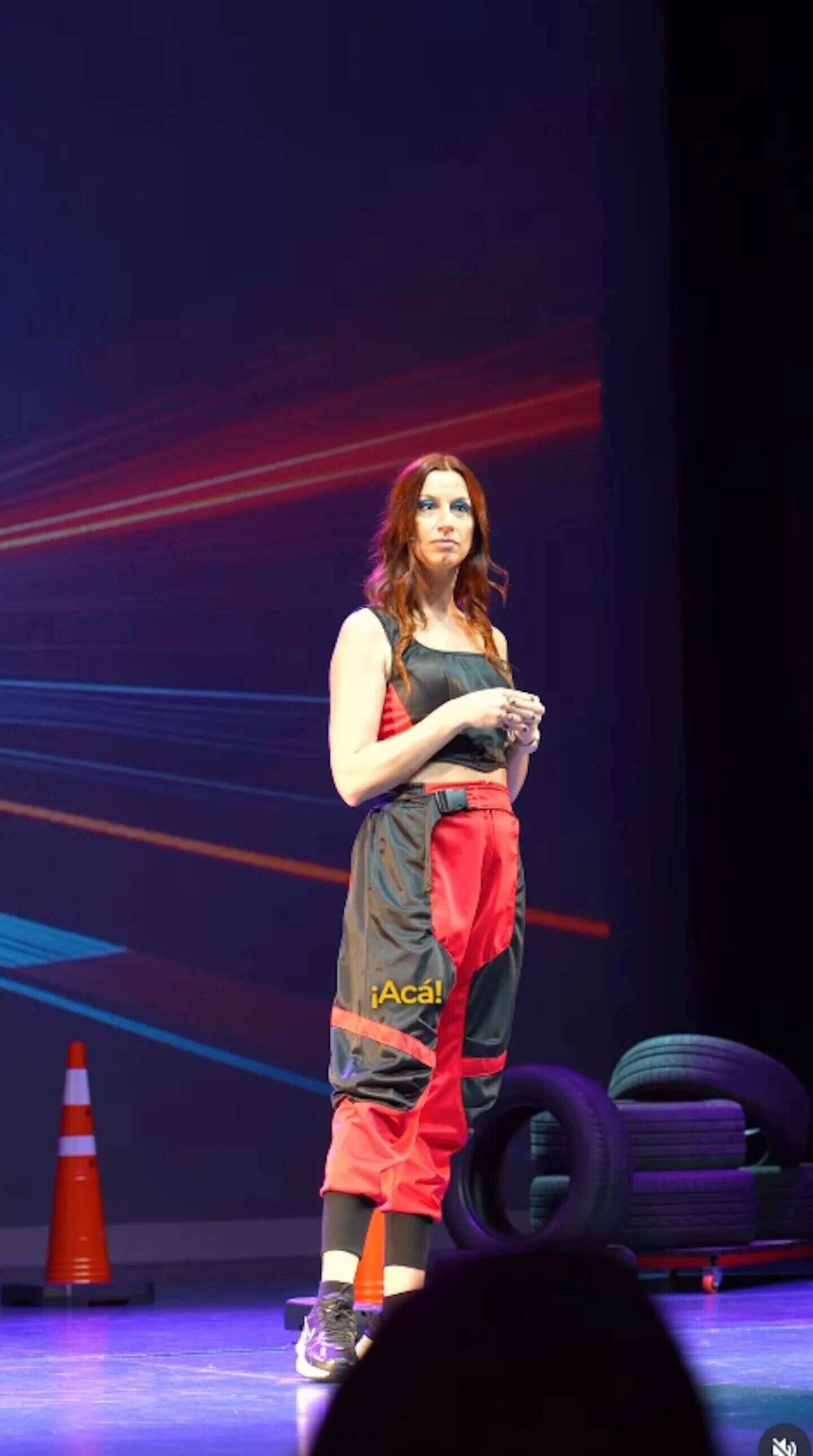Cecilia Ce en un escenario durante una presentación sobre maltrato emocional