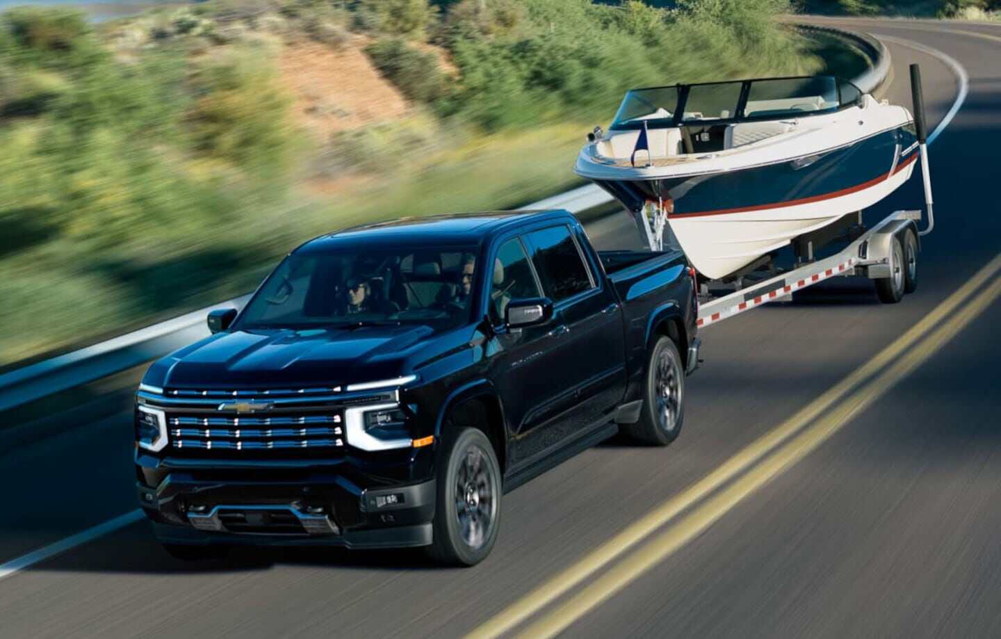 Chevrolet Silverado 2027 negra remolcando un bote en una carretera