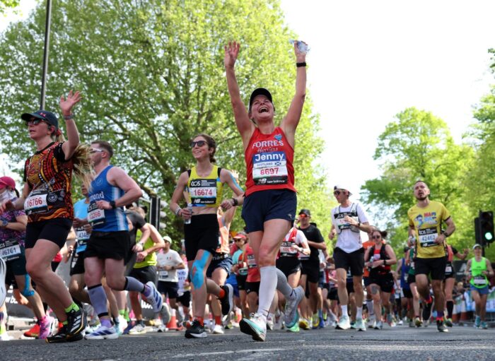 Corredores celebrando durante una media maratón en un ambiente festivo
