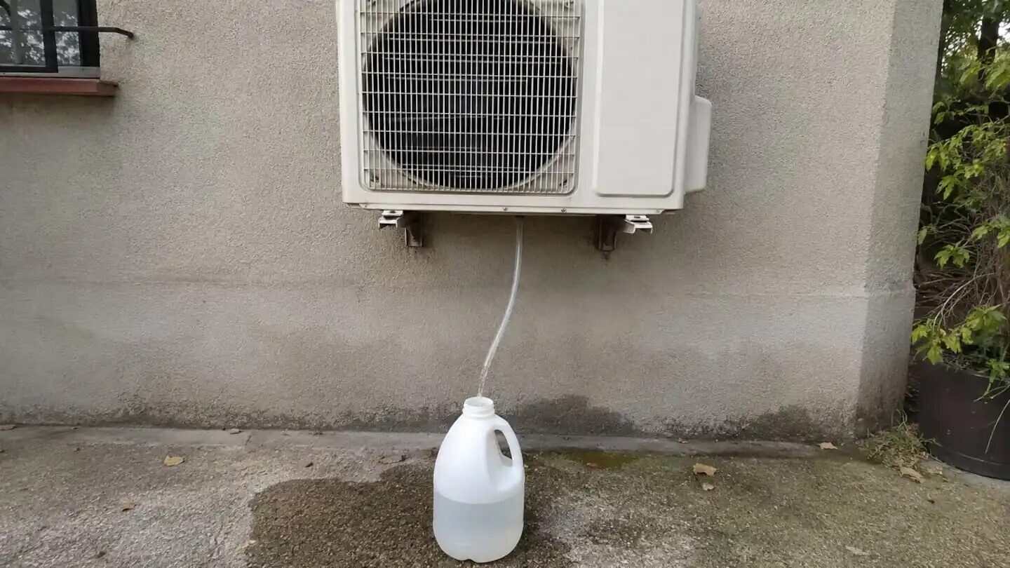 Recipiente recolectando agua del drenaje de un aire acondicionado