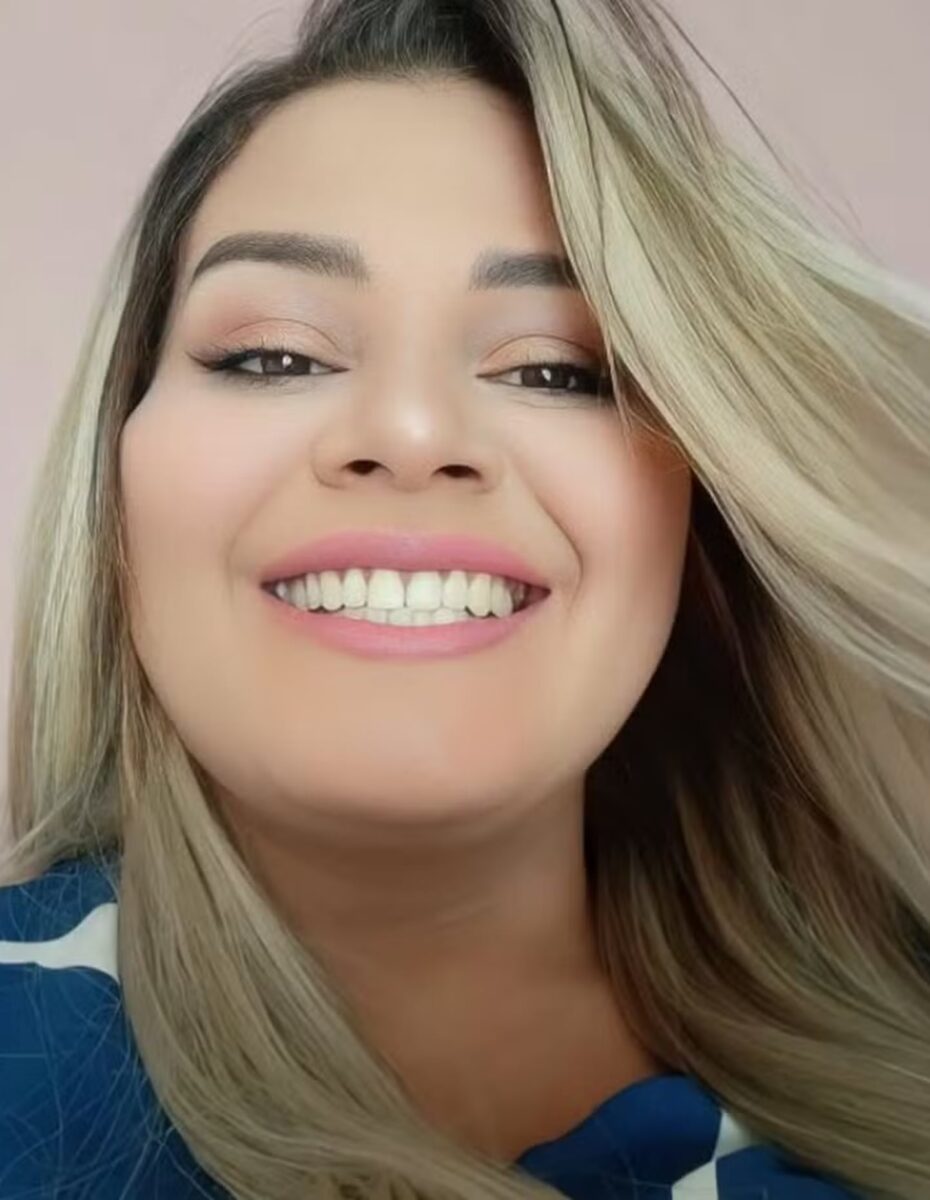 Mujer sonriendo con cabello rubio y blusa azul