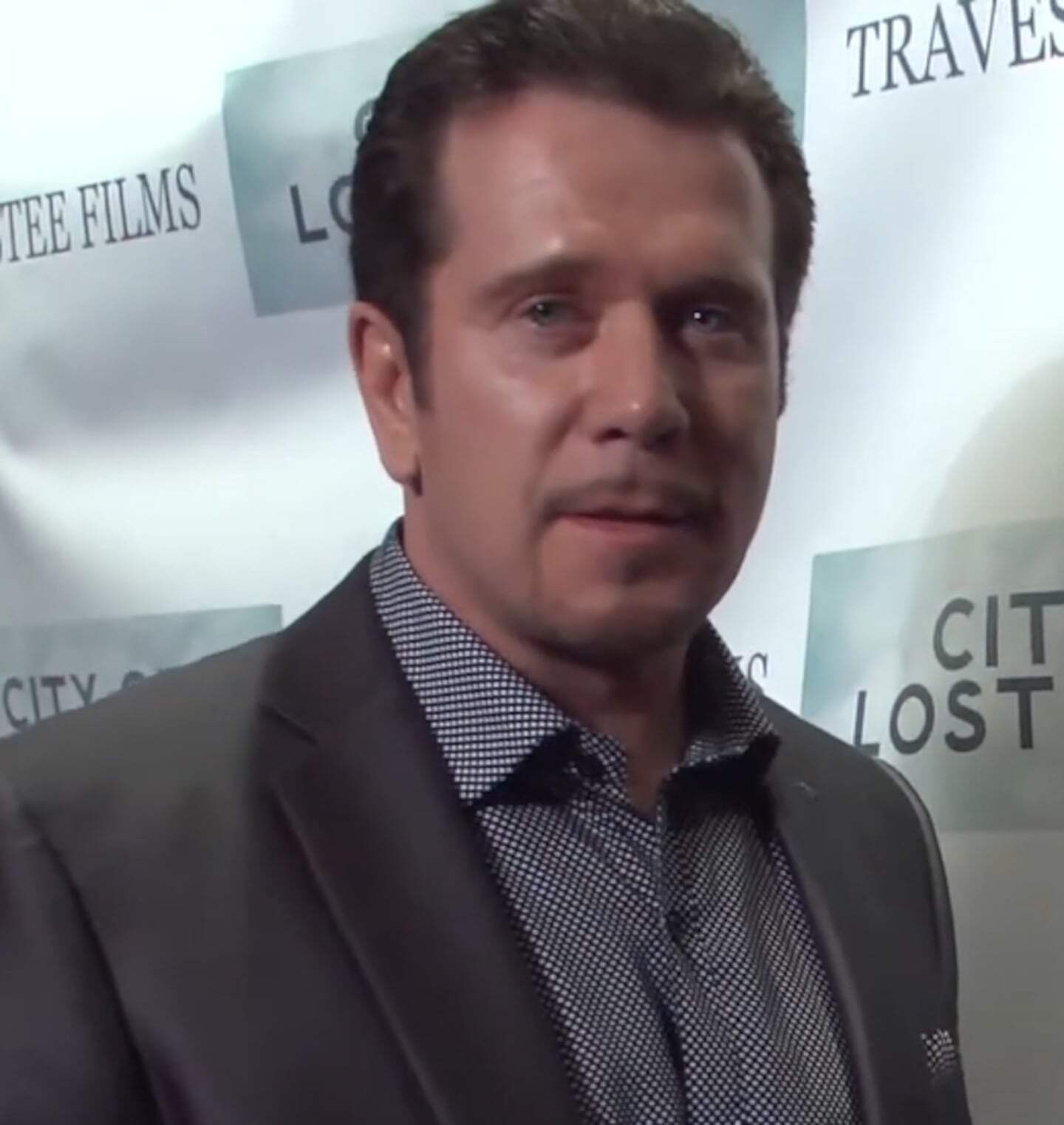 Bobby J. Brown en un evento de cine, luciendo un traje oscuro y una camisa de puntos