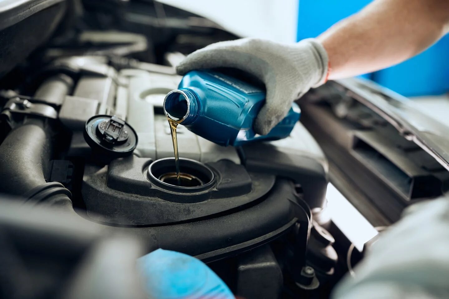 Un mecánico vierte aceite en el motor de un automóvil