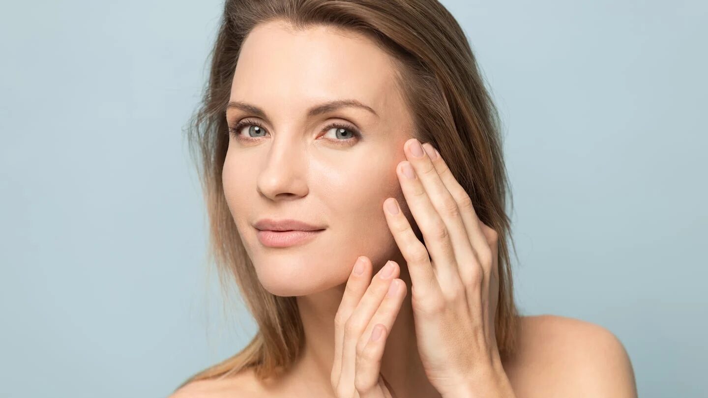 Mujer aplicando crema hidratante en su rostro para prevenir la resequedad en invierno