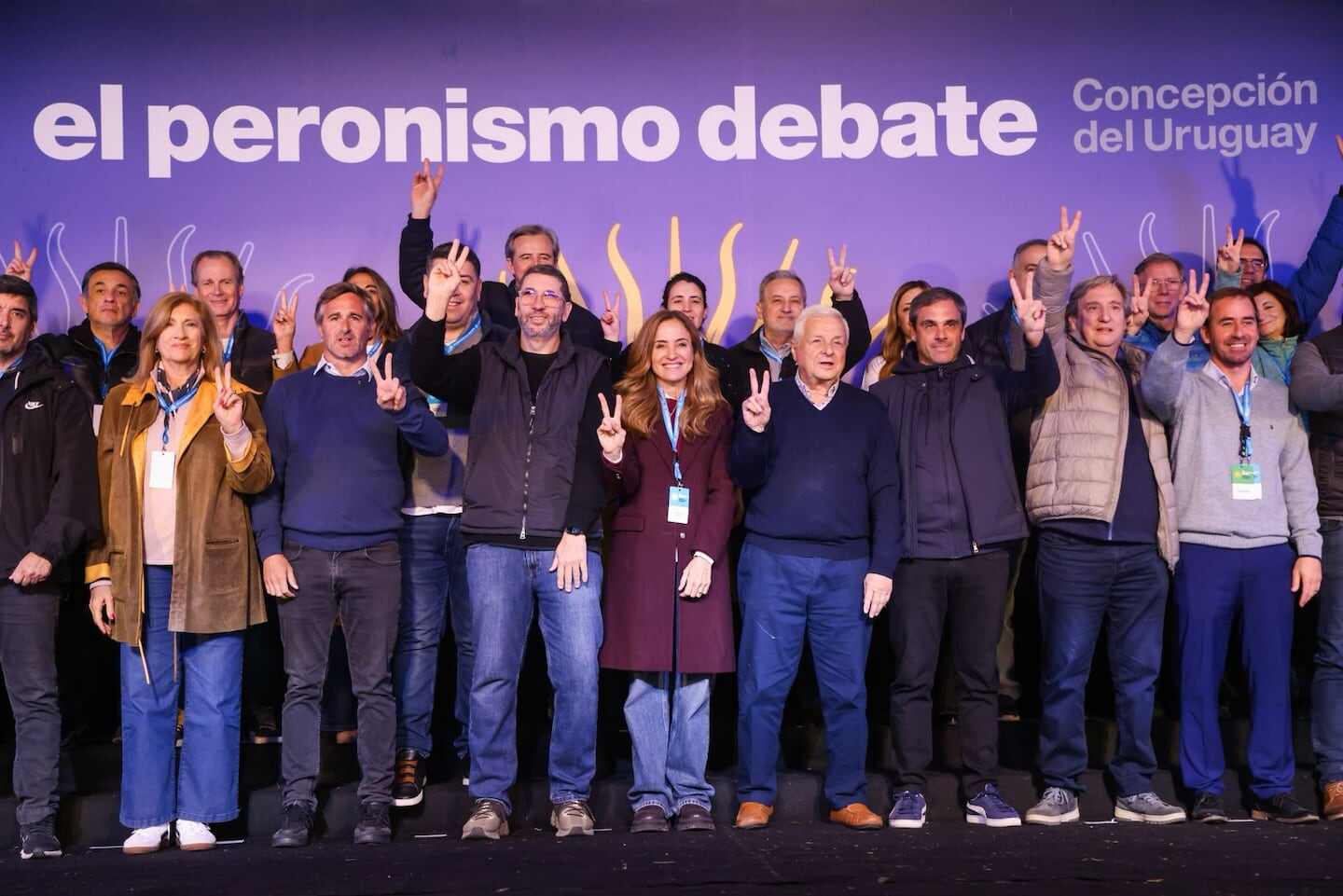 Grupo de líderes peronistas levantando los dedos en señal de victoria en un evento en Concepción del Uruguay
