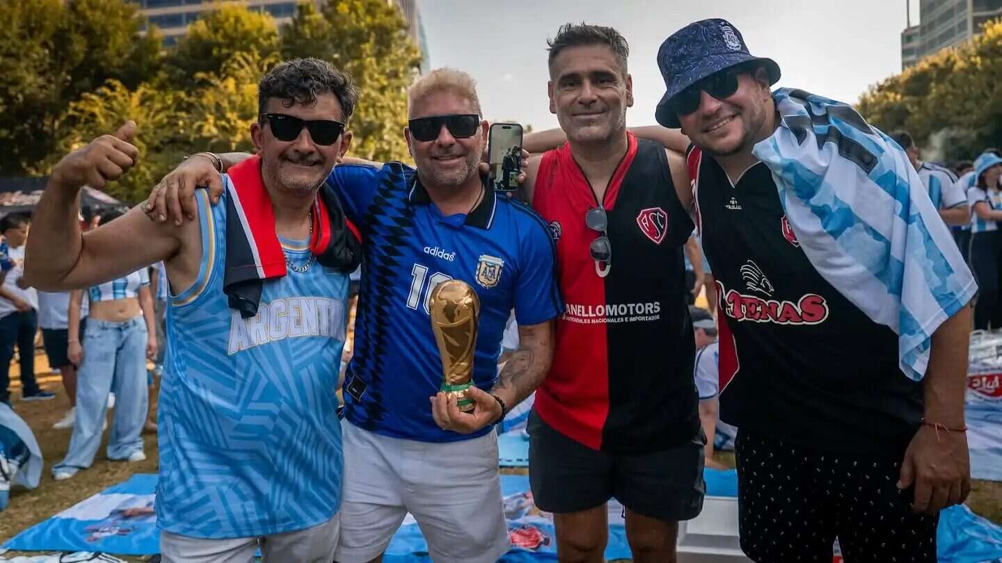 Cuatro amigos mendocinos posando juntos con la copa del Mundial en Dallas