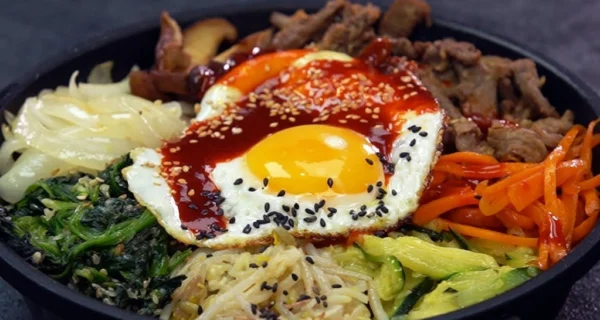 Plato de bibimbap con arroz, verduras y huevo