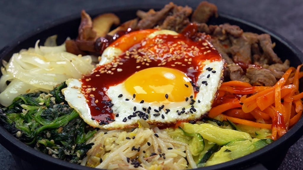 Plato de bibimbap con arroz, verduras y huevo