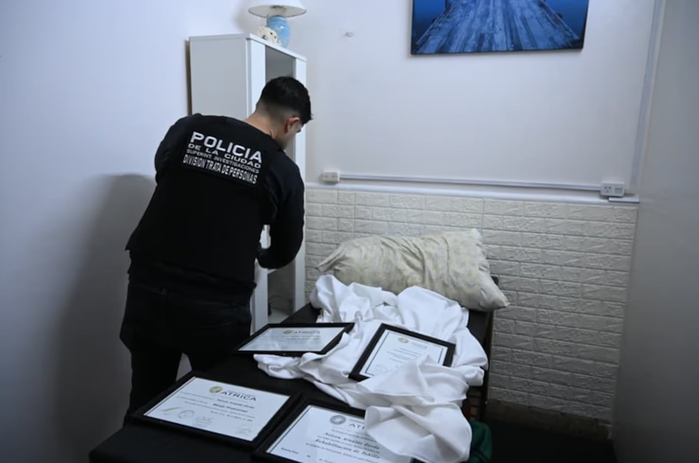 Agente de la Policía de la Ciudad revisando un cuarto en un falso spa en Caballito