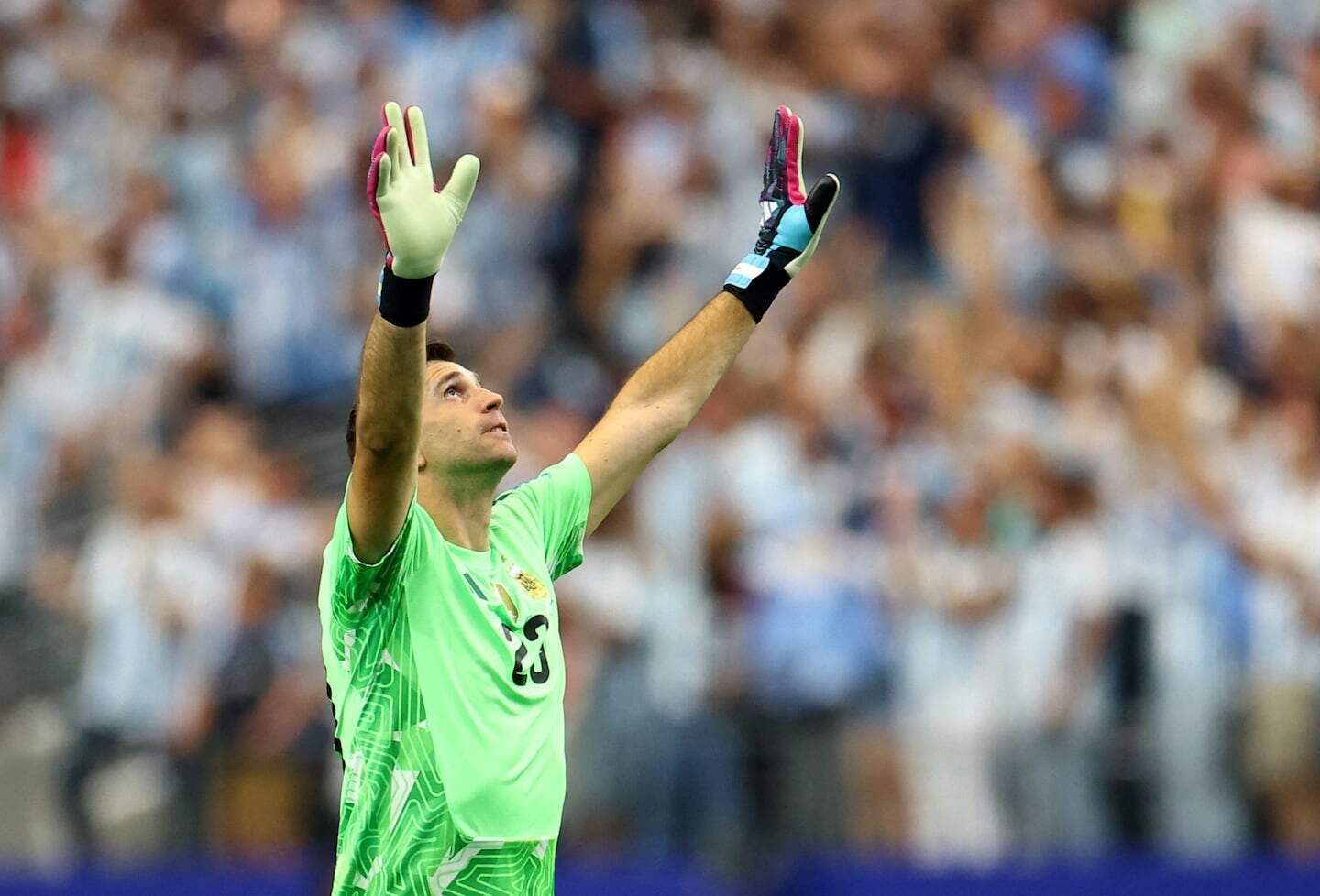 Dibu Martínez en el campo, levantando las manos en señal de agradecimiento tras el partido de Argentina contra Austria