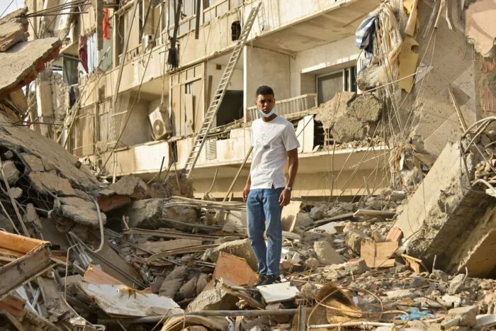 Hombre de pie entre escombros tras un sismo en Venezuela