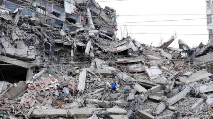 Edificio colapsado tras un sismo, mostrando escombros y estructuras dañadas