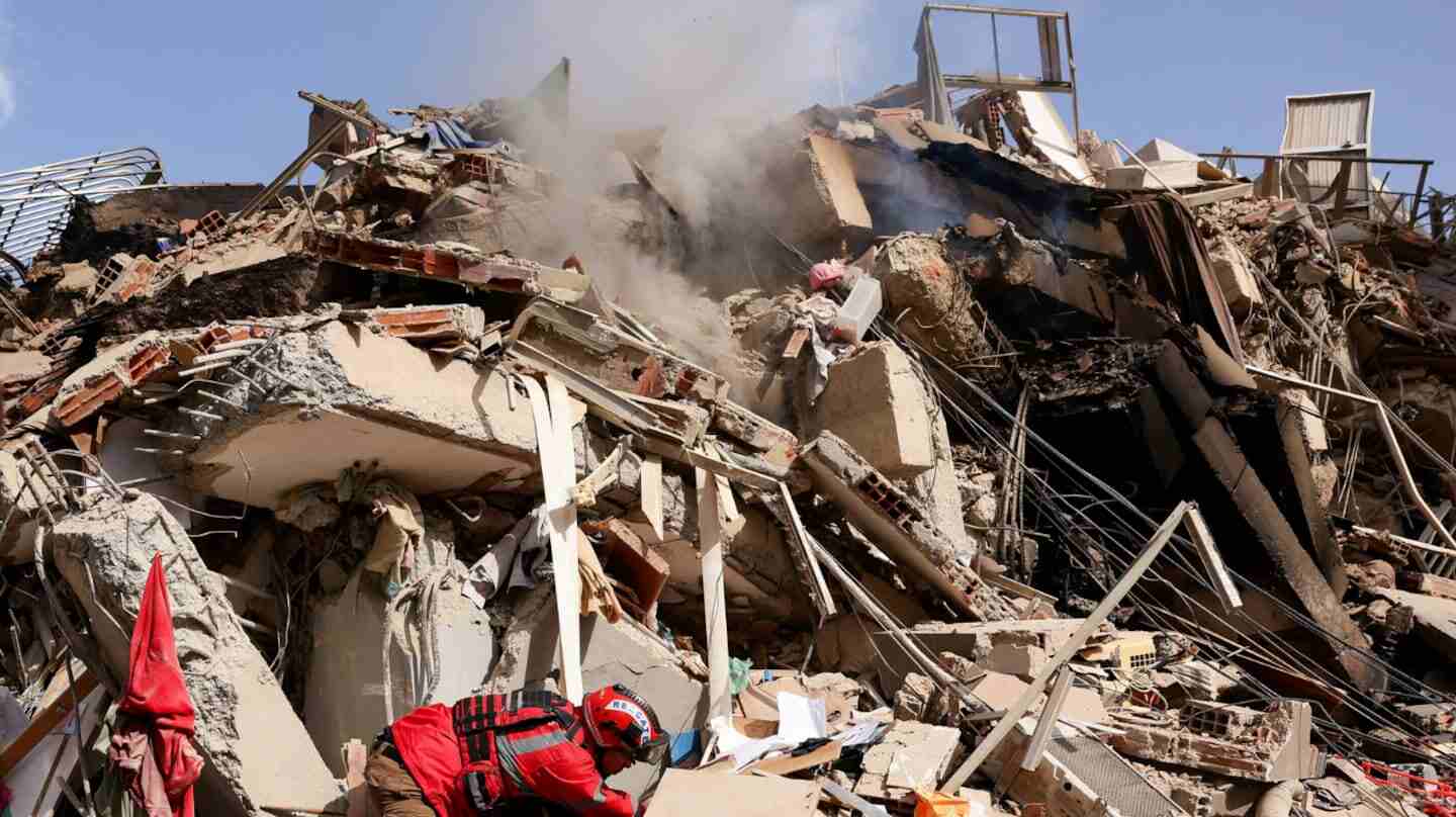 Edificio colapsado tras un doble sismo, con un rescatista trabajando entre los escombros