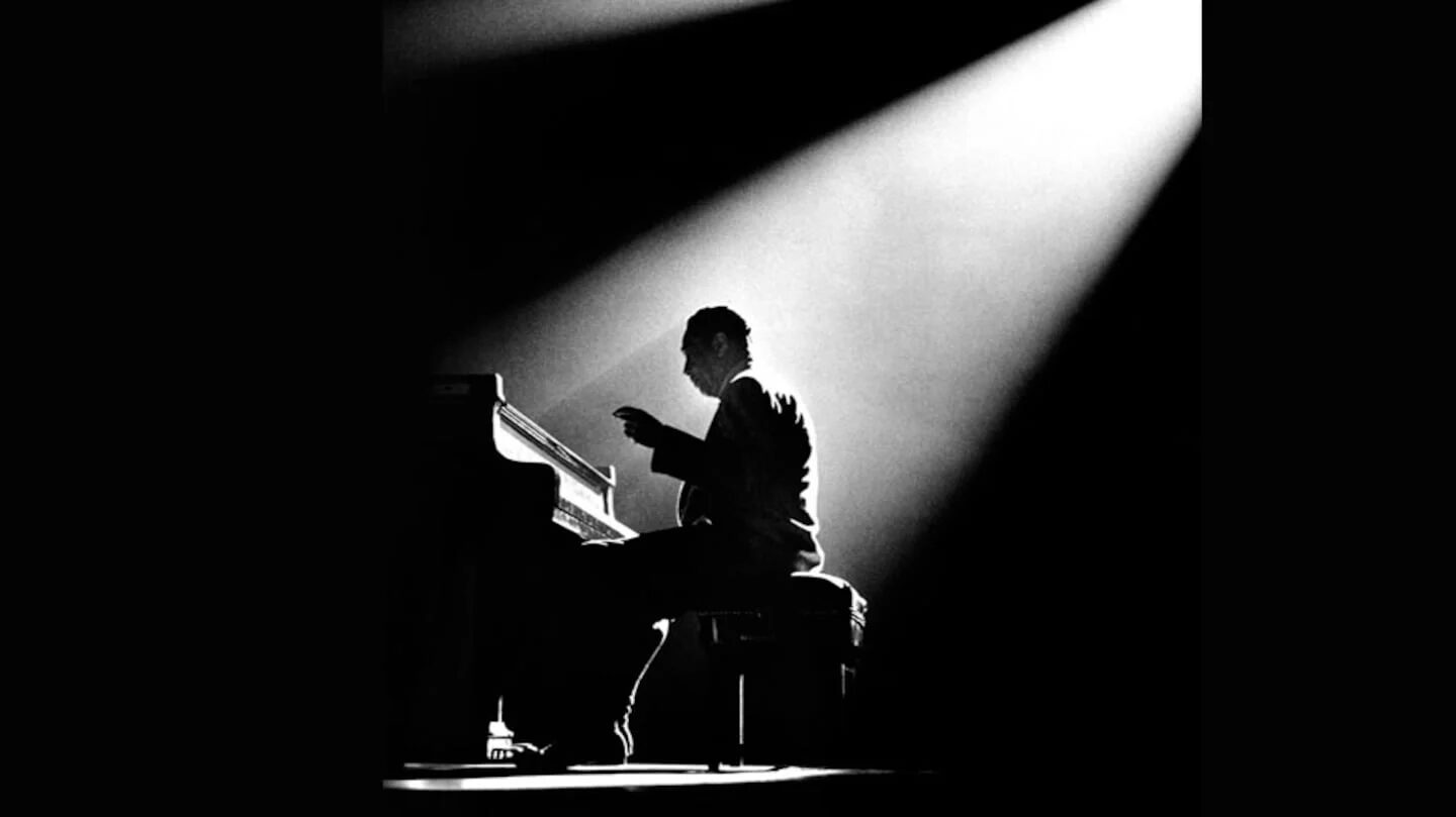 Duke Ellington tocando el piano bajo un haz de luz