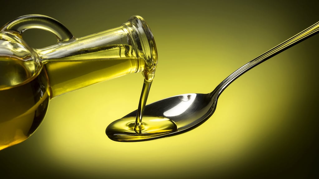 Aceite de oliva en una botella con aceitunas