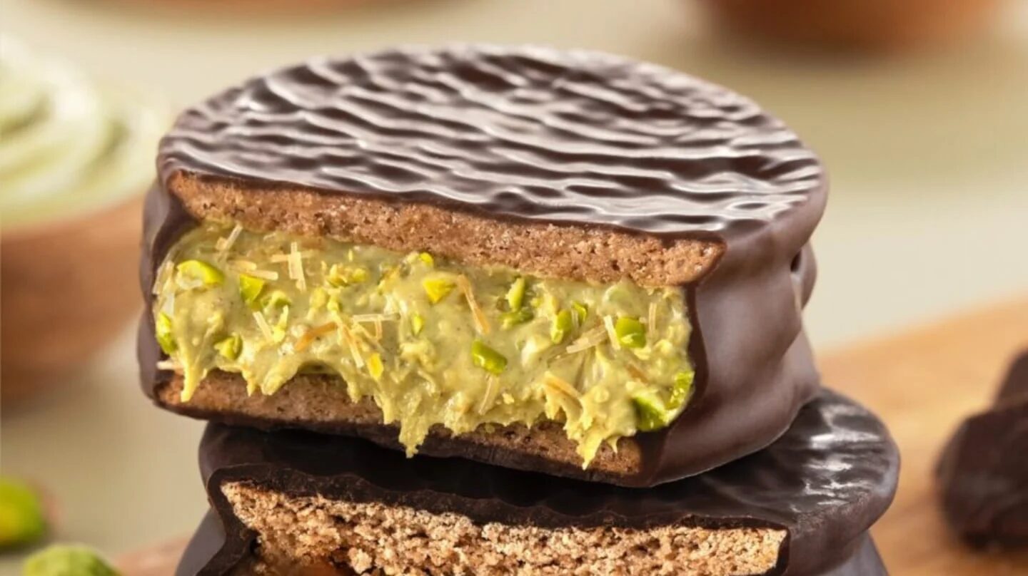 Alfajor de chocolate con relleno de crema de pistacho y trozos de nuez