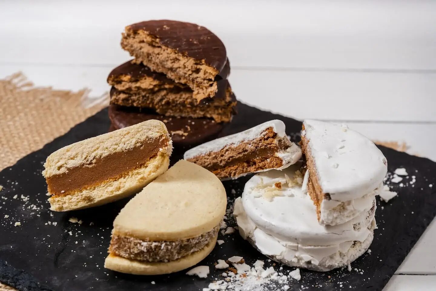 Variedades de alfajores argentinos sobre una bandeja de piedra