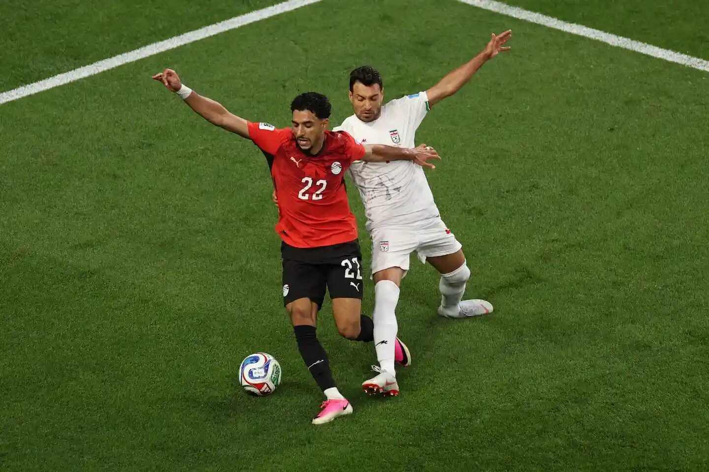Jugador de Egipto y jugador de Irán en una disputa durante un partido de fútbol