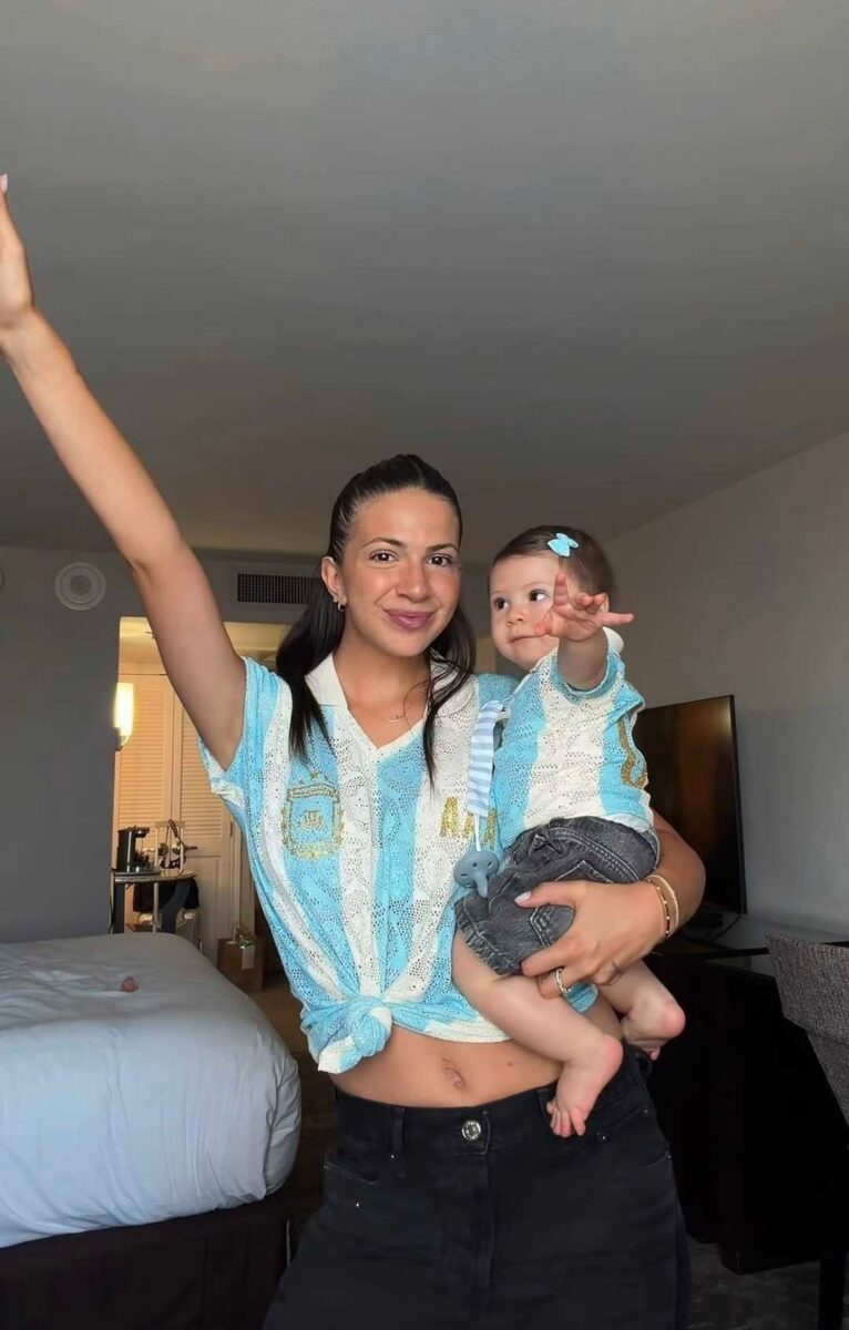 Ailén Cova sostiene a su hija mientras celebra con una camiseta de la selección argentina