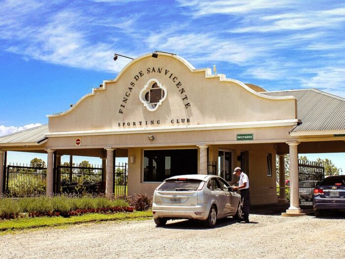Entrada del Fincas de San Vicente Sporting Club con vehículos en el acceso