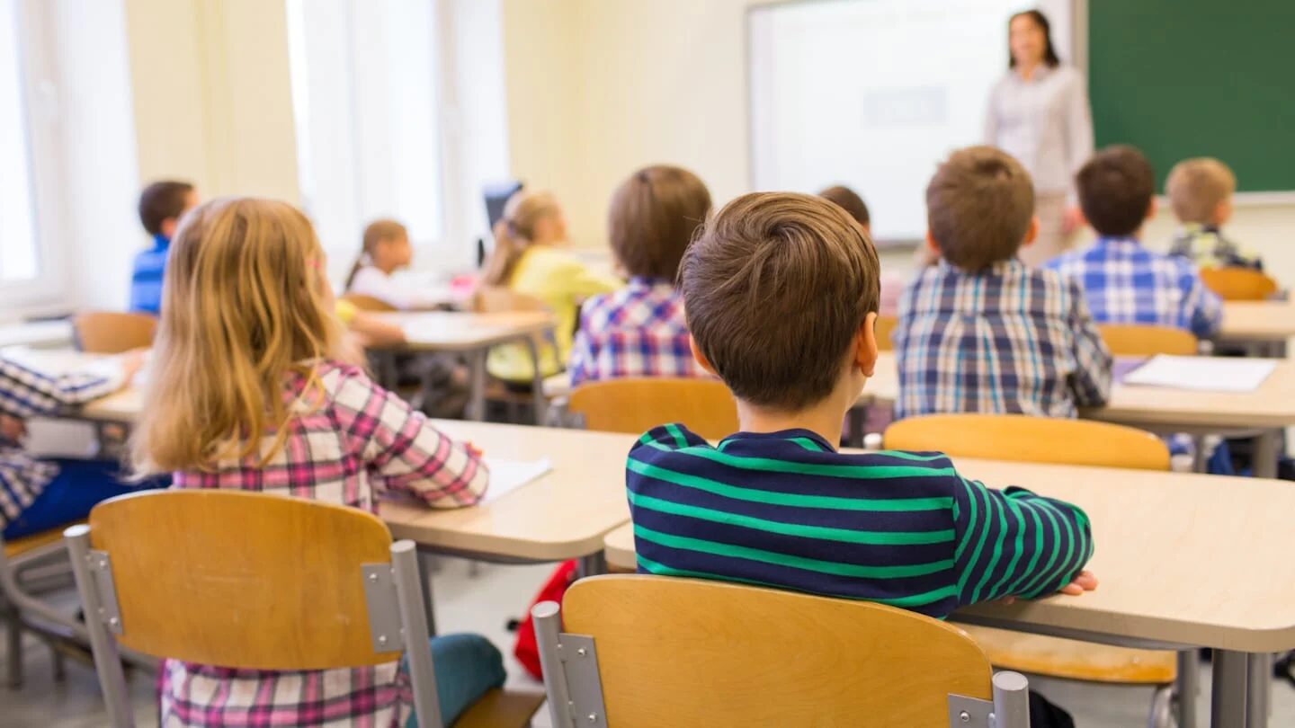Niños en un aula escuchando a una docente en Argentina
