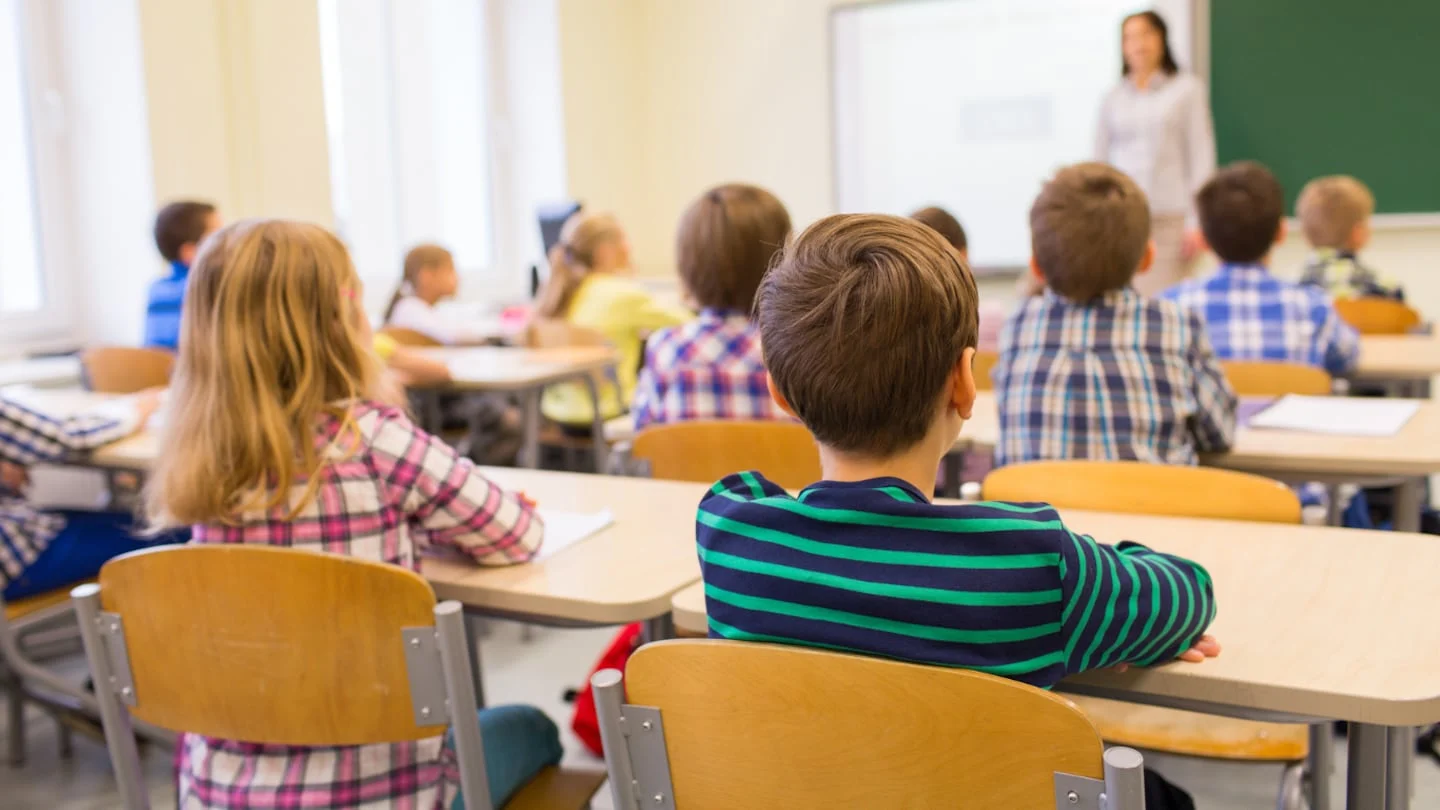 Niños en un aula escuchando a una docente en Argentina