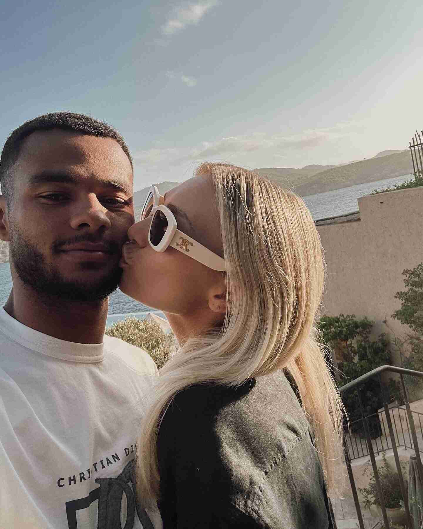 Cody Gakpo posando con su pareja junto al mar