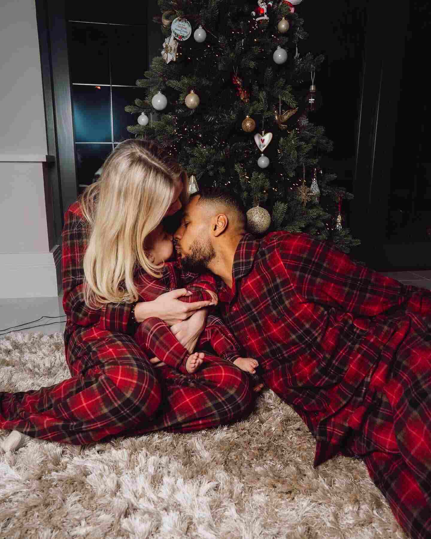 Cody Gakpo y su pareja se besan mientras sostienen a su bebé frente a un árbol de Navidad