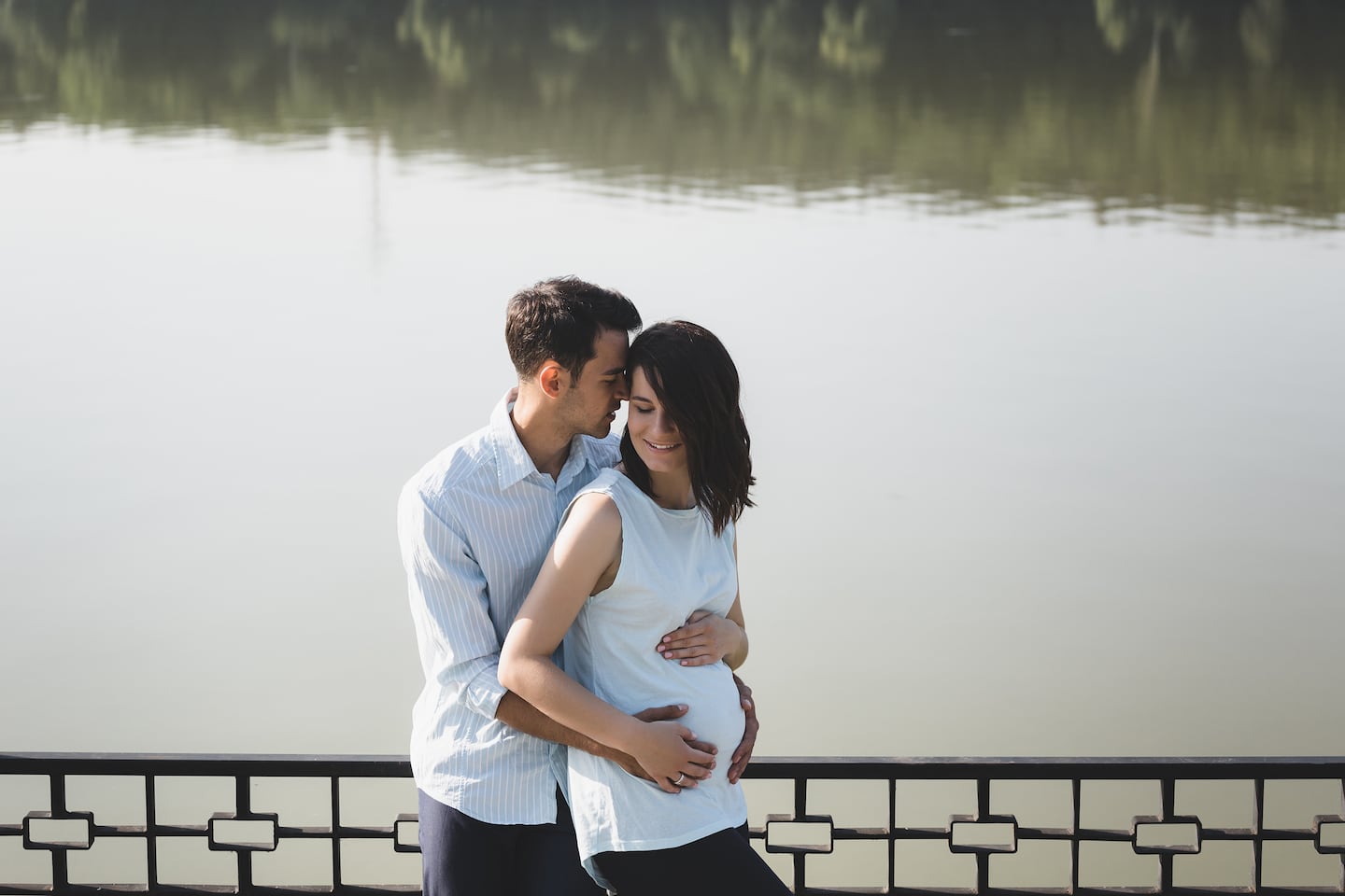 Pareja embarazada disfrutando de un momento juntos junto a un lago