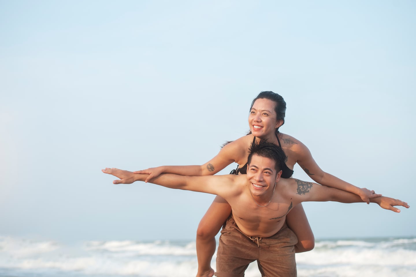 Pareja disfrutando de un momento juntos en la playa durante su babymoon